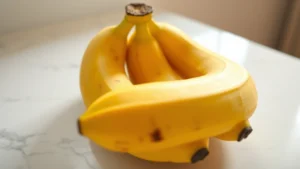 Close-up of three very ripe bananas with brown spots on yellow skin, arranged on white marble countertop with natural morning light, photorealistic food photography